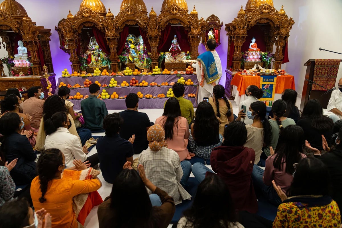 people gather for a religious ceremony at the Dharmic Center