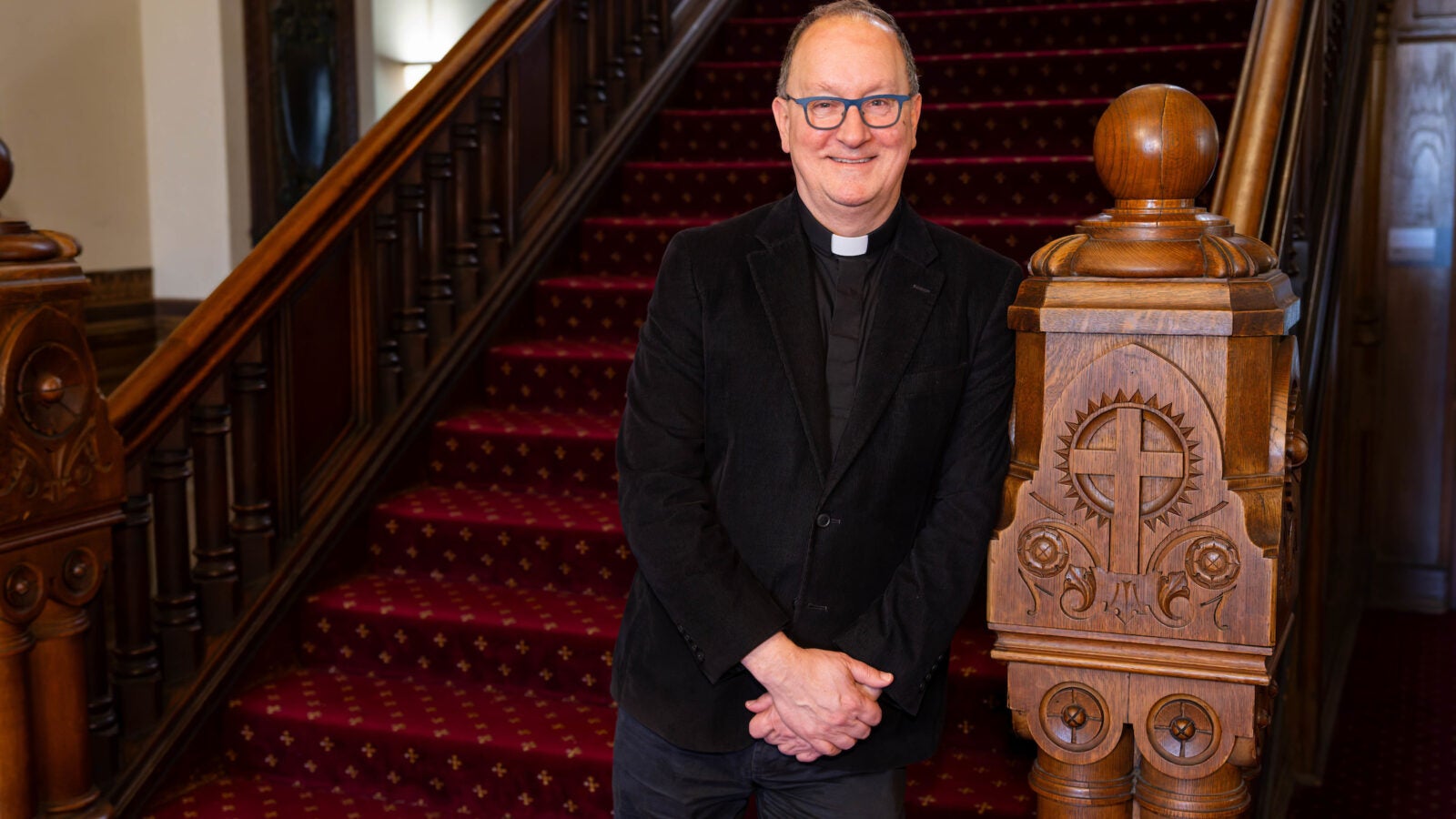 a priest stands at the beginning of a staircase