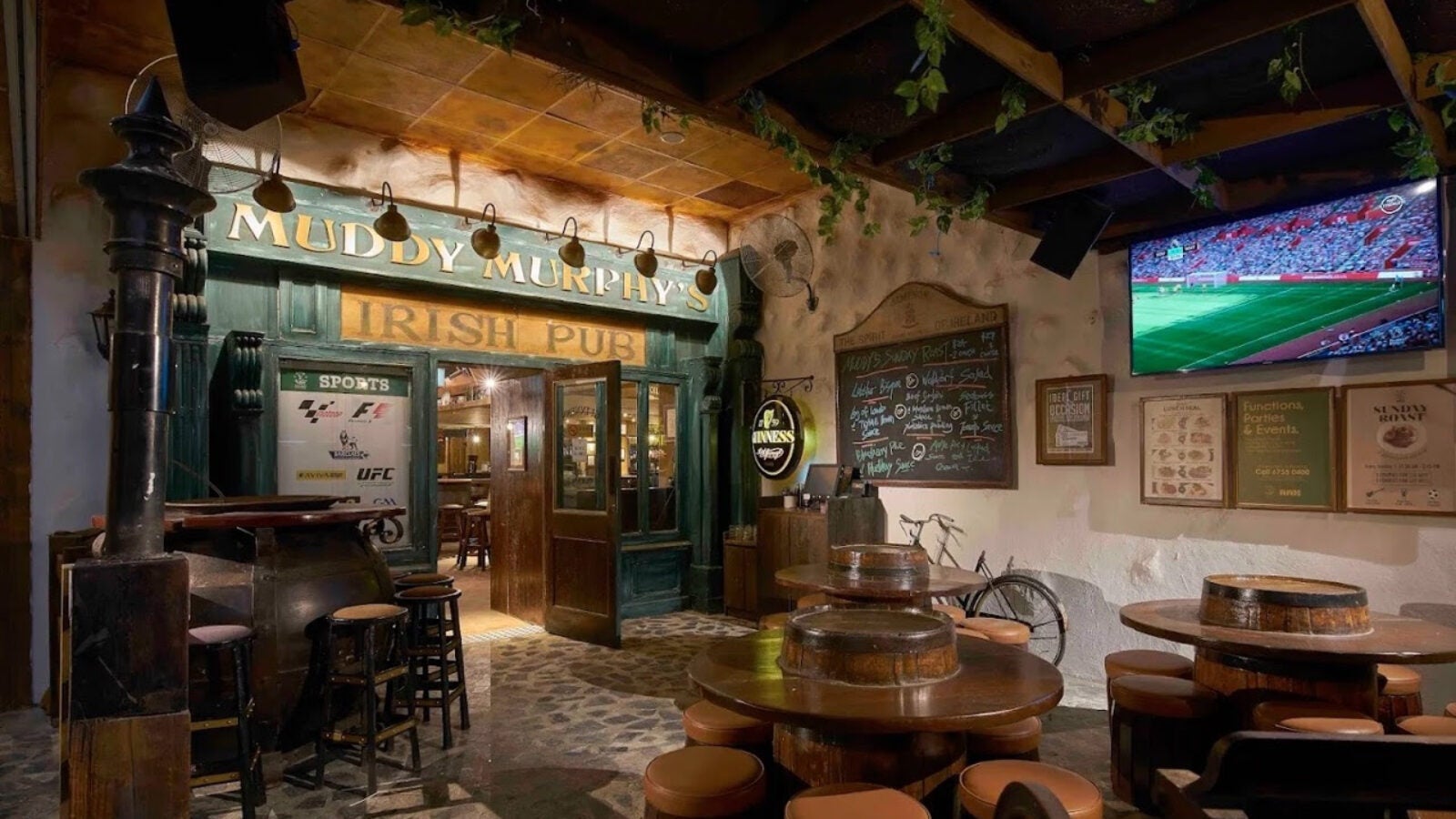 Entrance to Muddy Murphy's, an Irish Pub in Singapore. Wooden tables, stools, and doors fill the frame