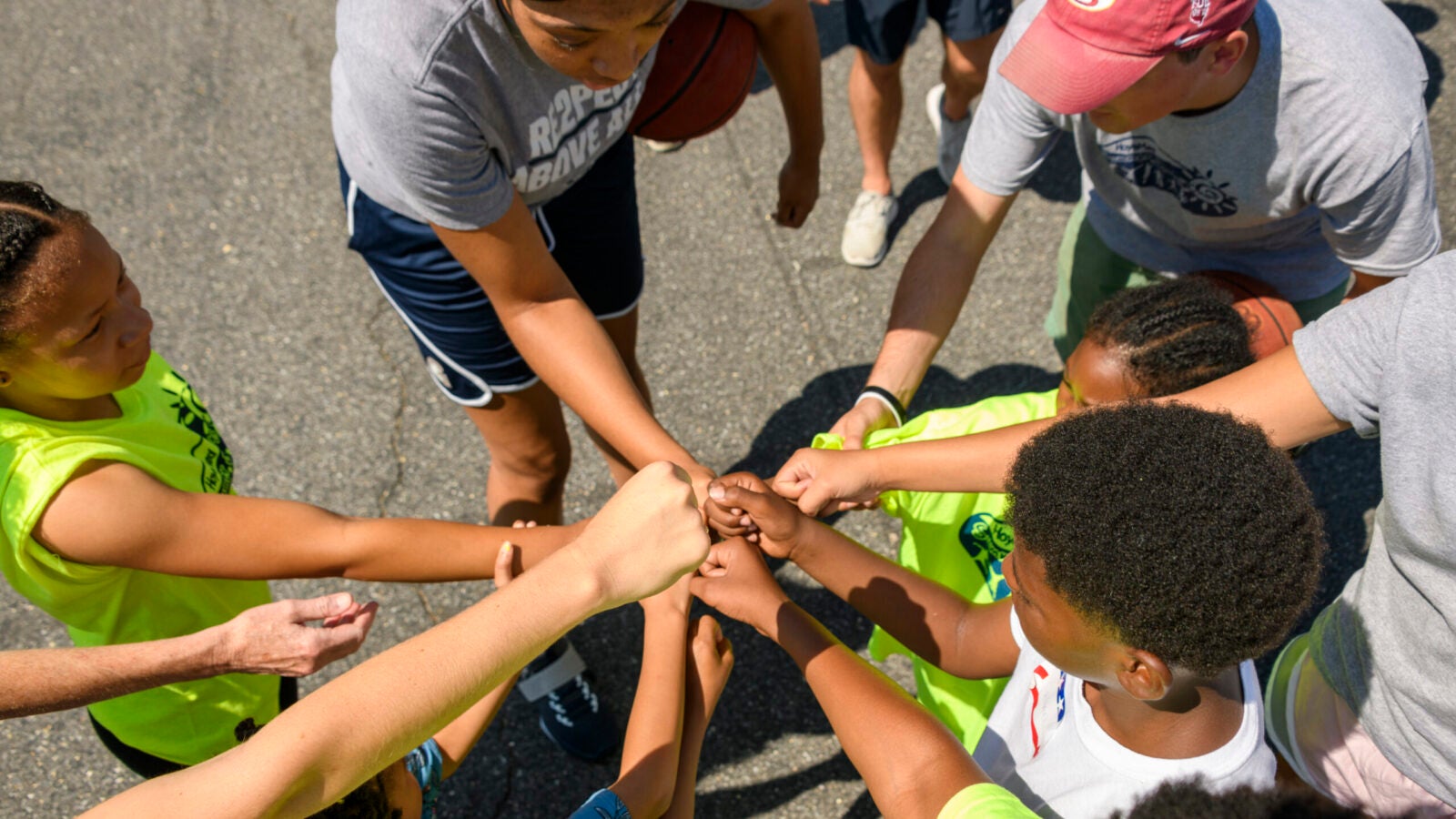 people putting hands into middle in a group
